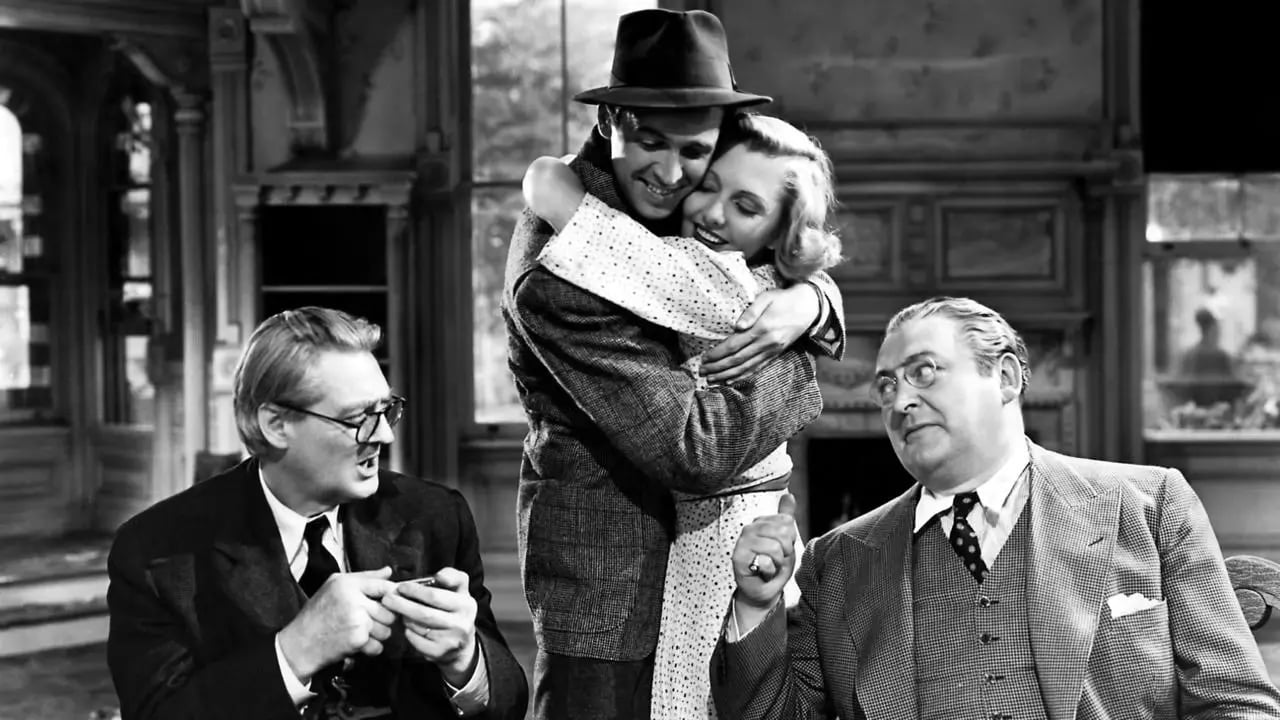 Jimmy Stewart and Jean Arthur hugging between Lionel Barrymore, Jr. and Edward Arnold